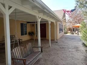 a view of a porch with furniture and a yard