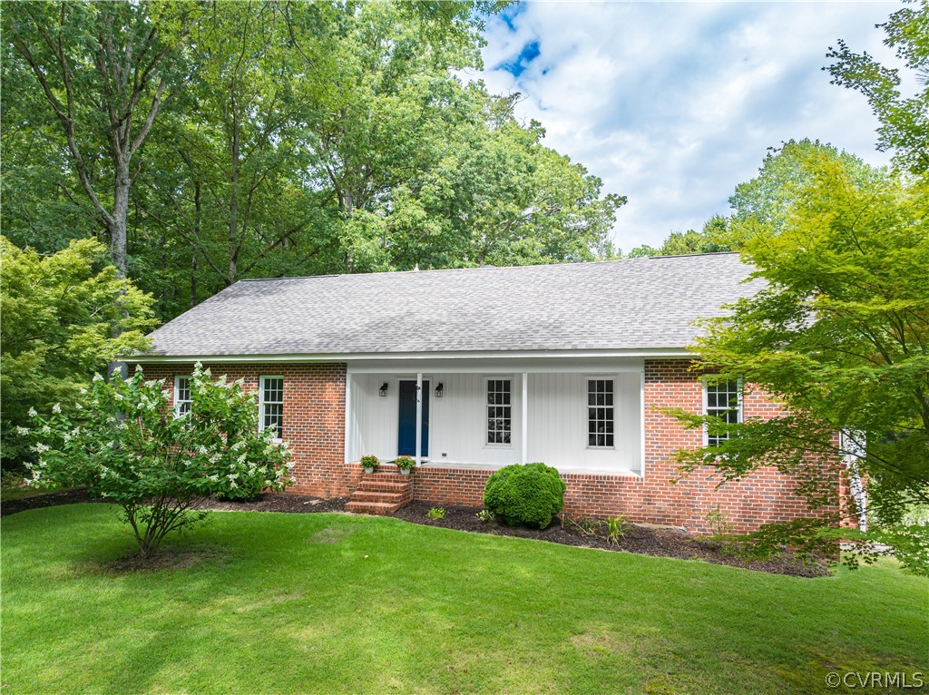 a backyard of a house with plants and large tree