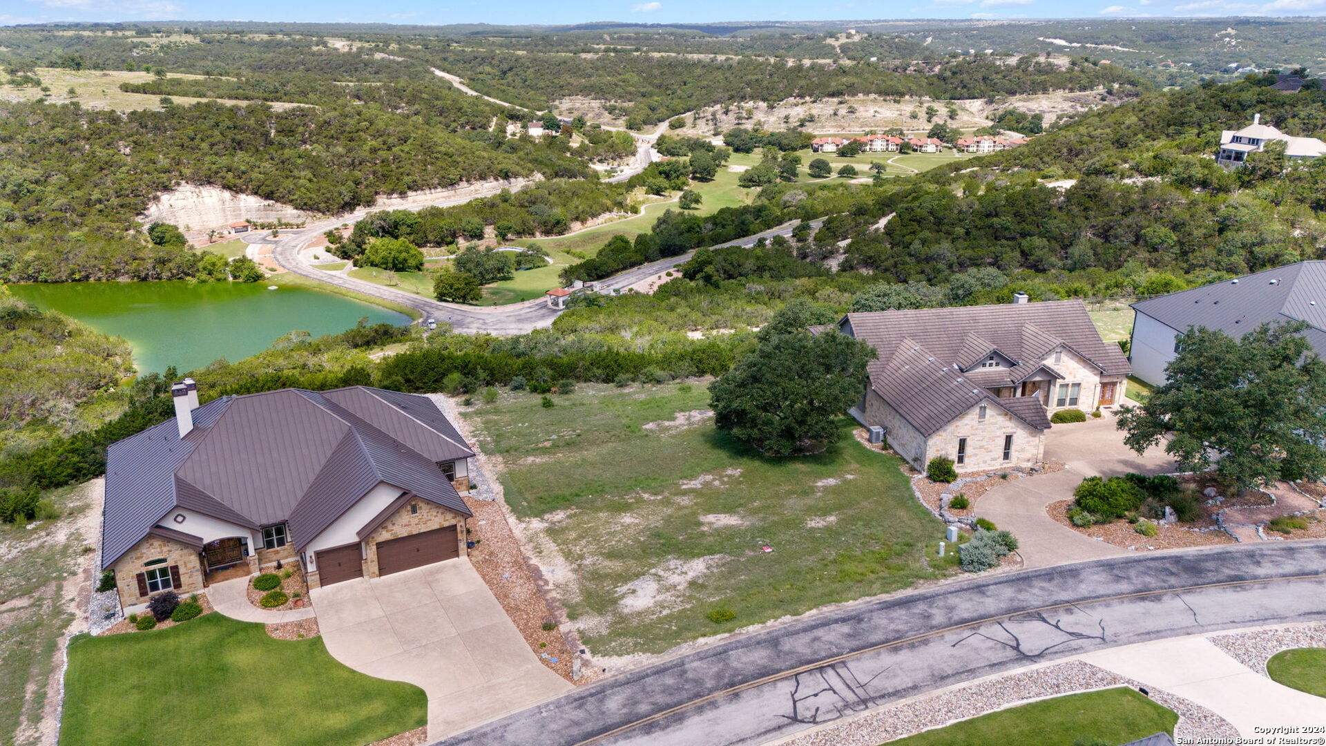 an aerial view of residential houses with outdoor space and river