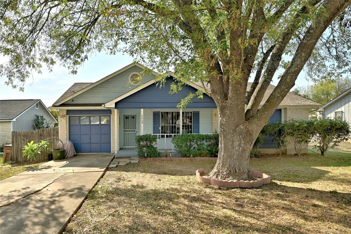 a front view of a house with a yard and potted plants