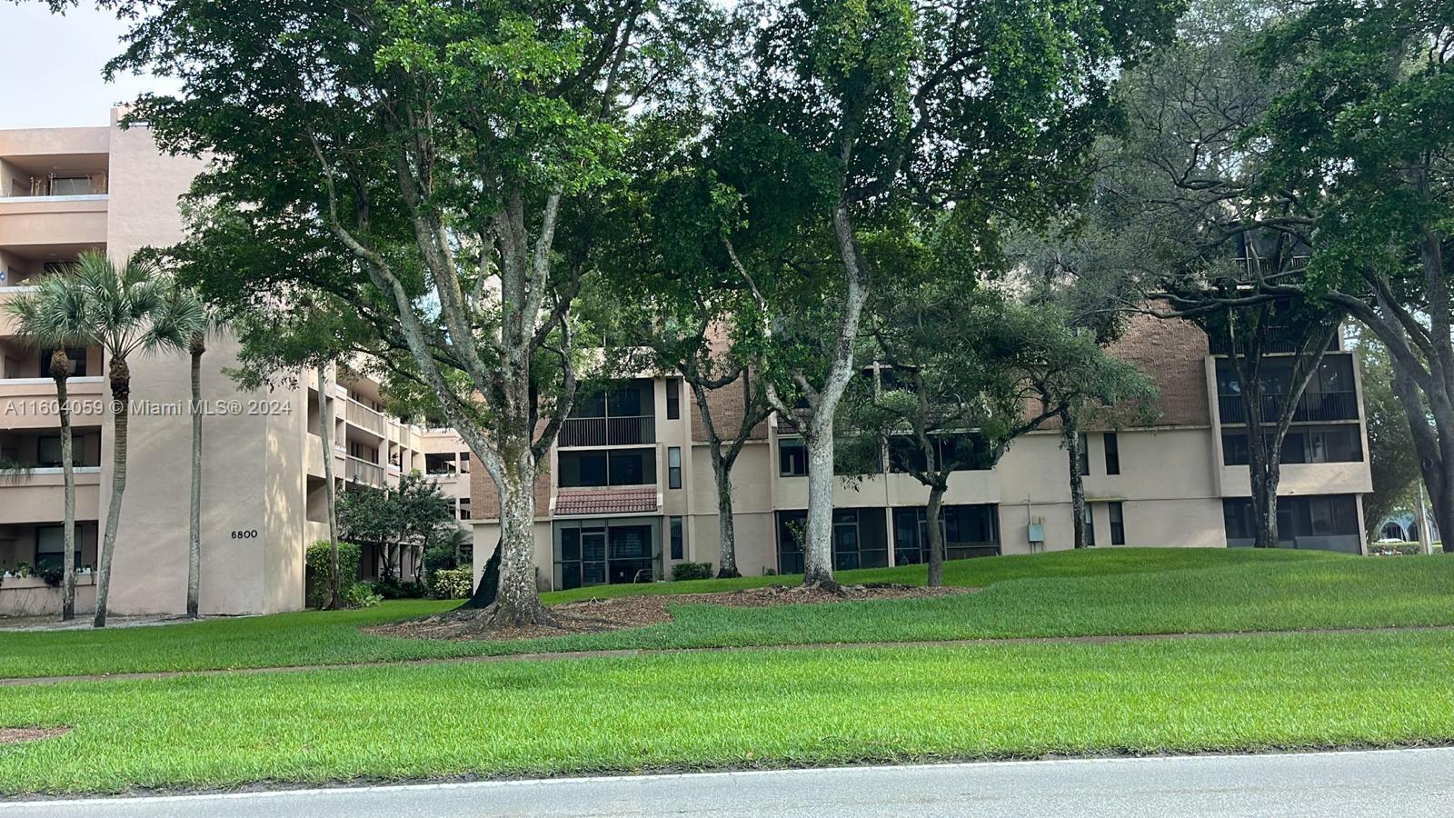 a view of a house with a big yard and large trees