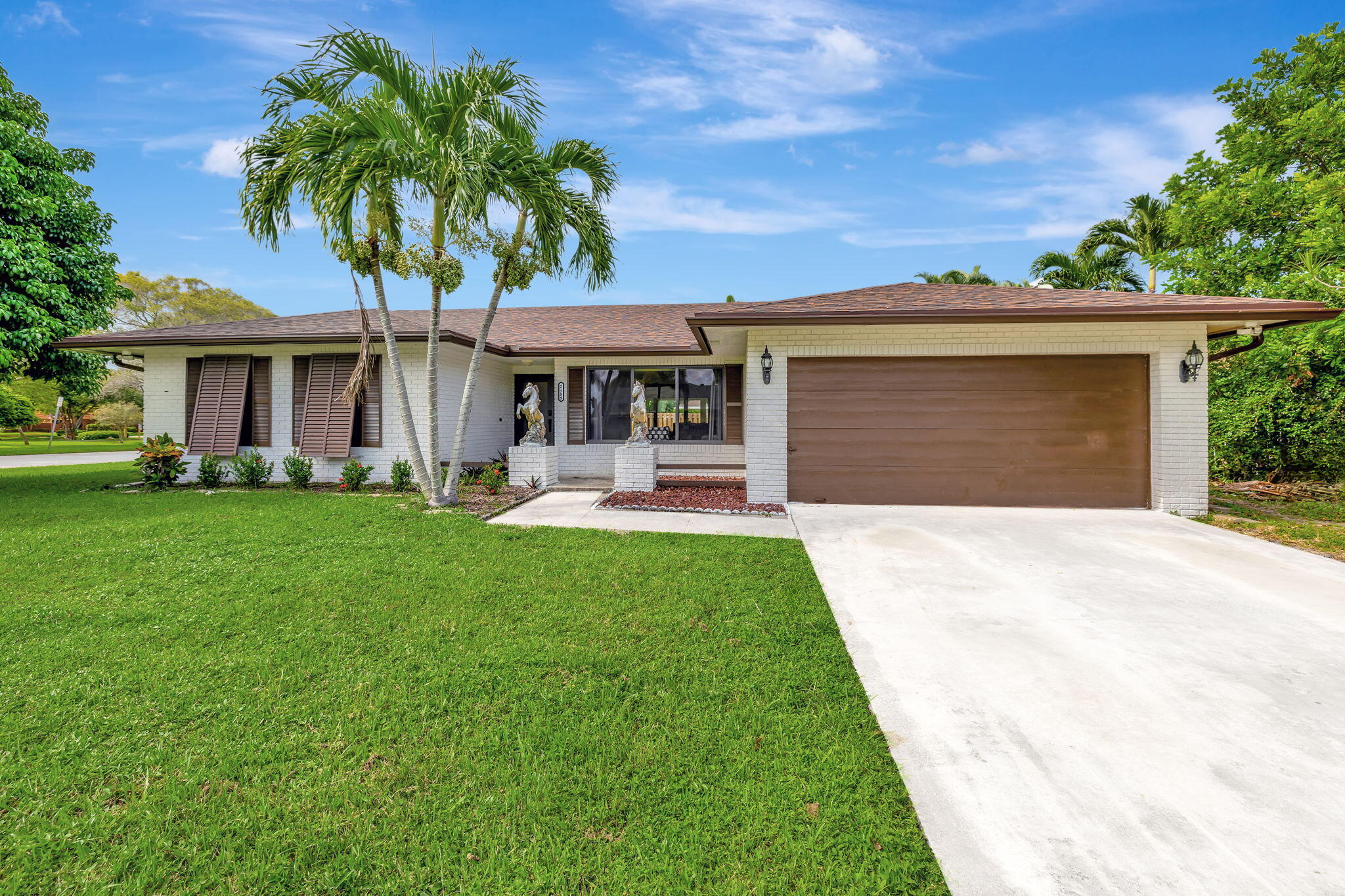 a front view of a house with a yard and palm tree