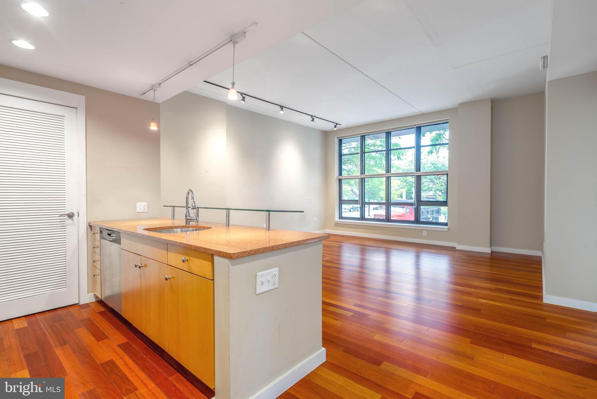 a view of a kitchen sink and wooden floor