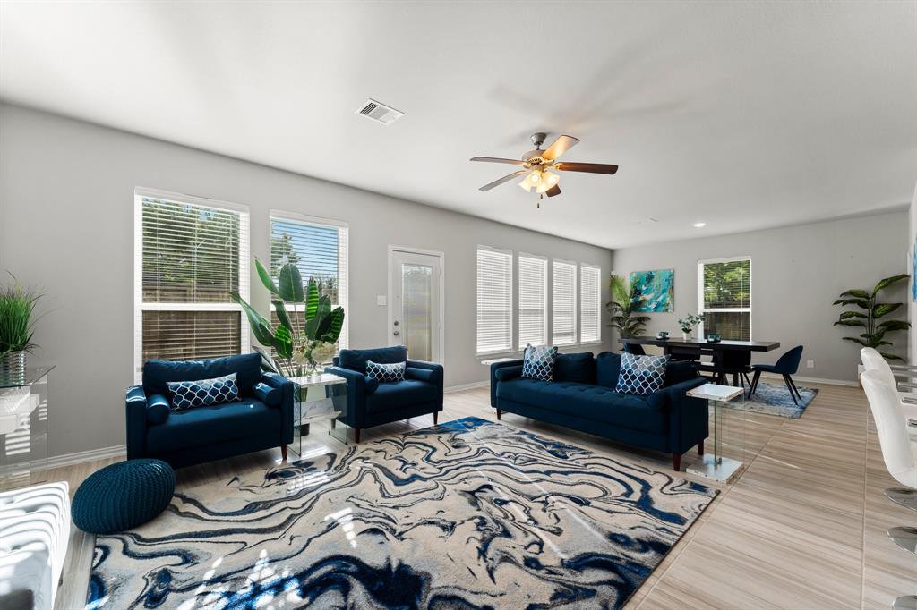 a living room with furniture a chandelier and a rug