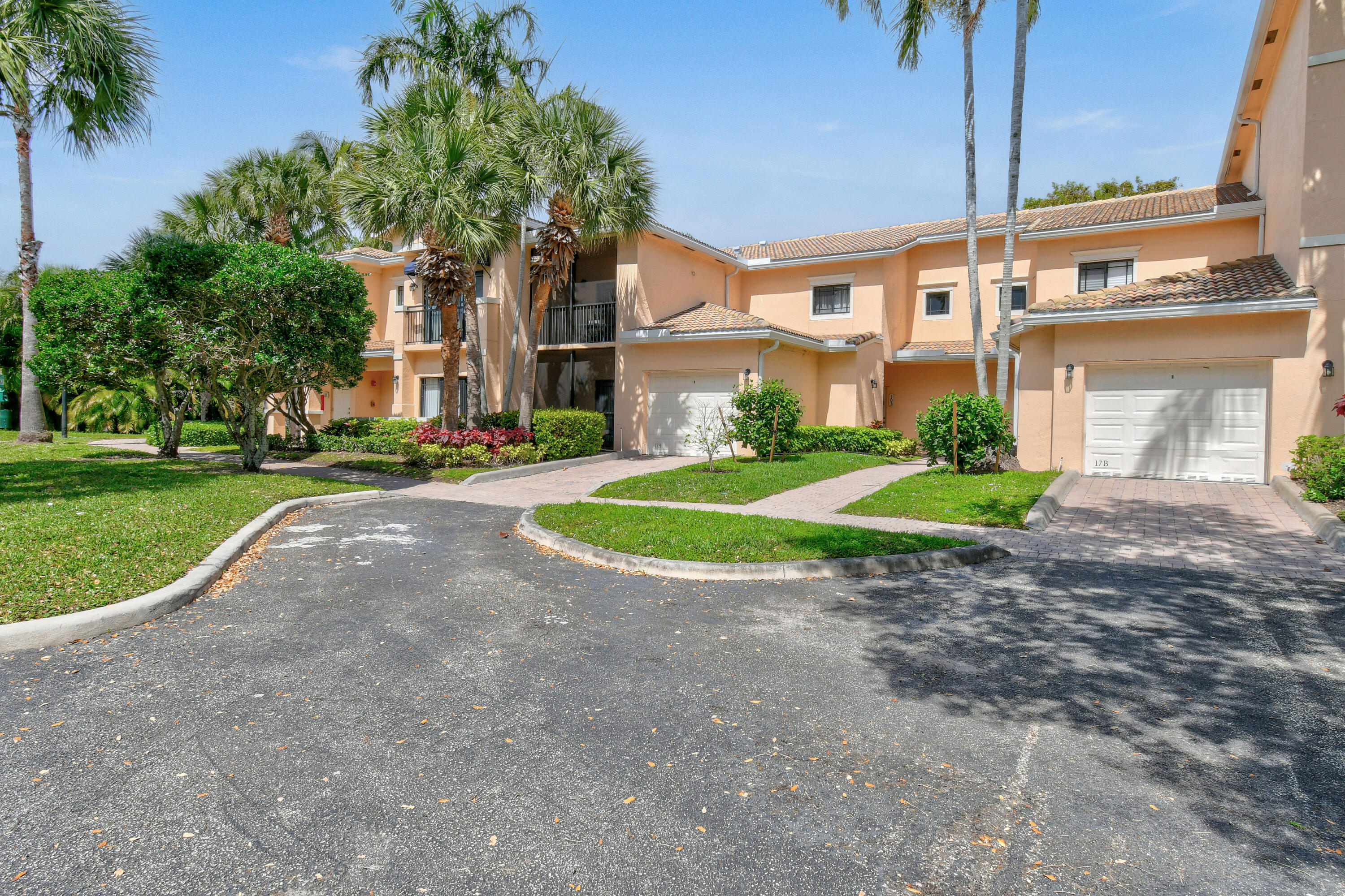 a view of a house with a yard and palm trees