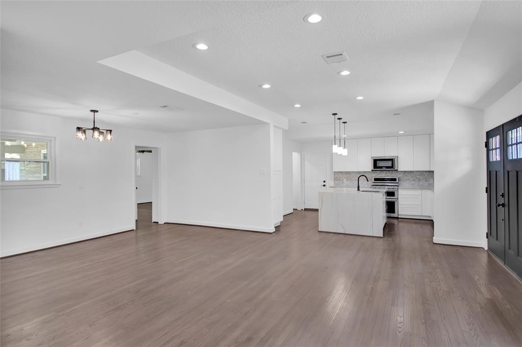 a view of kitchen with kitchen island wooden floor appliances and cabinets