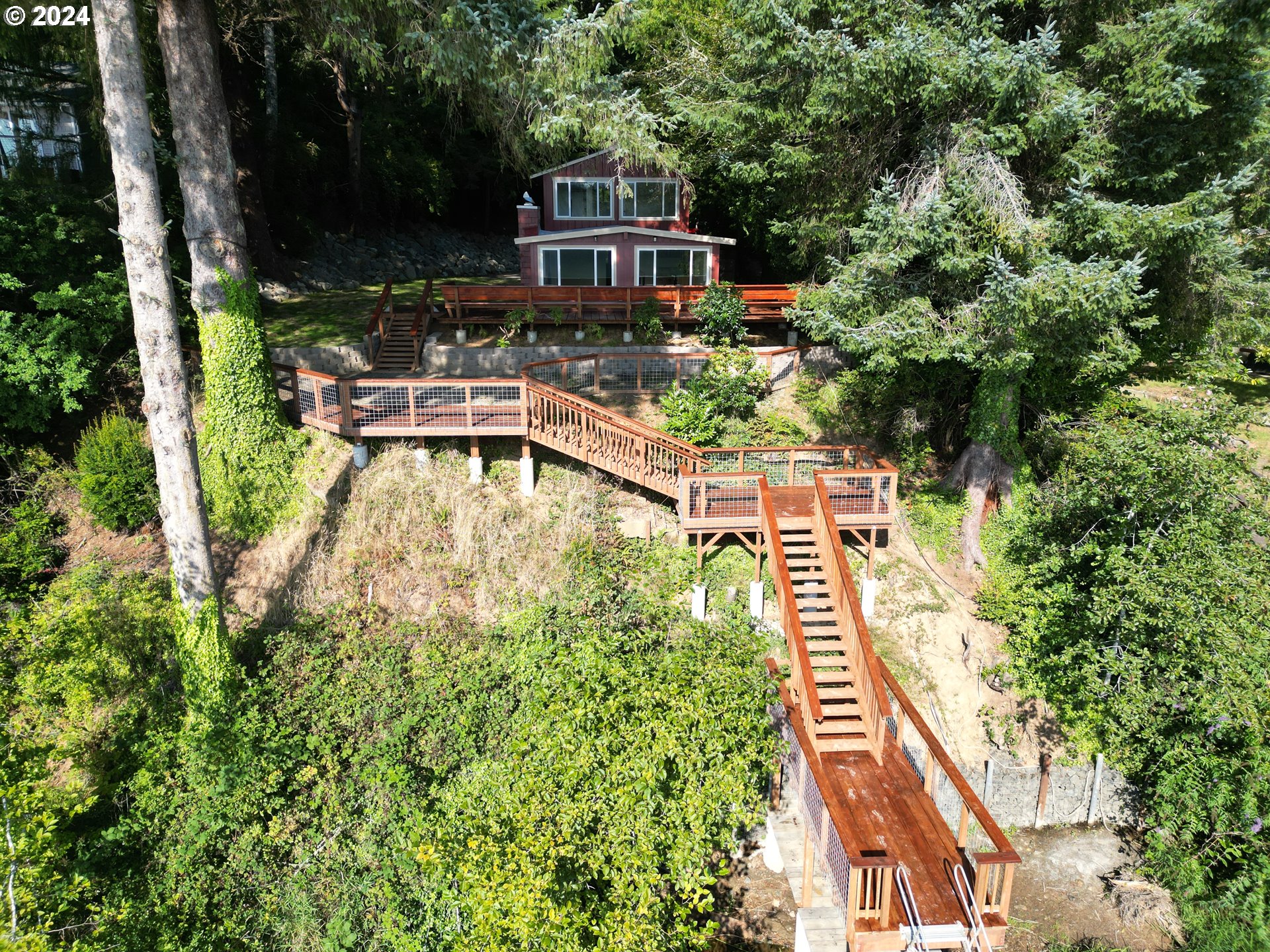 an aerial view of a house with swimming pool and large trees