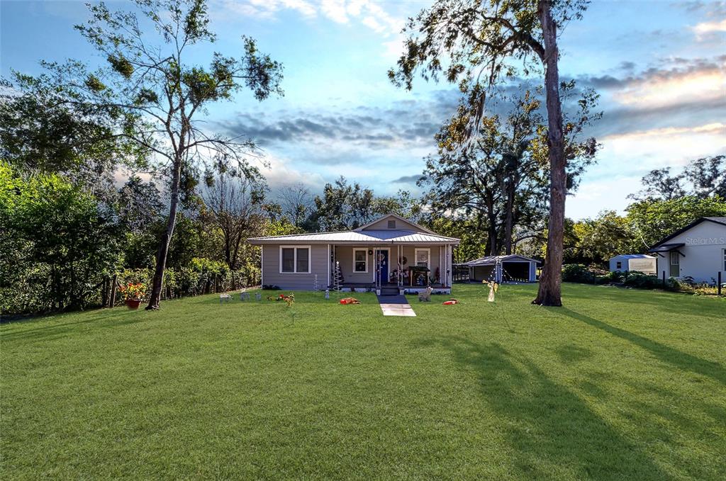 a view of a house with a yard and sitting area