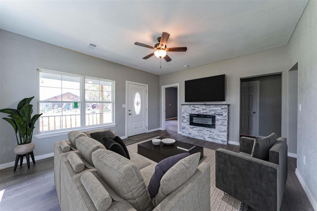 a living room with furniture a flat screen tv and a fireplace