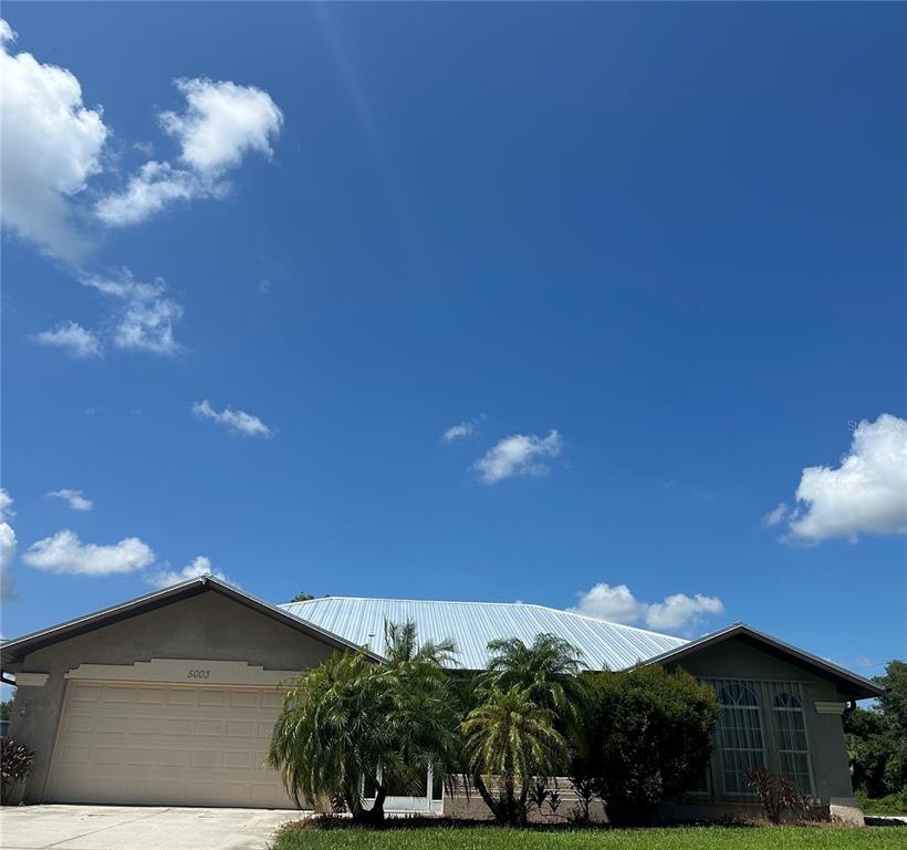 a view of a house with a yard and garage