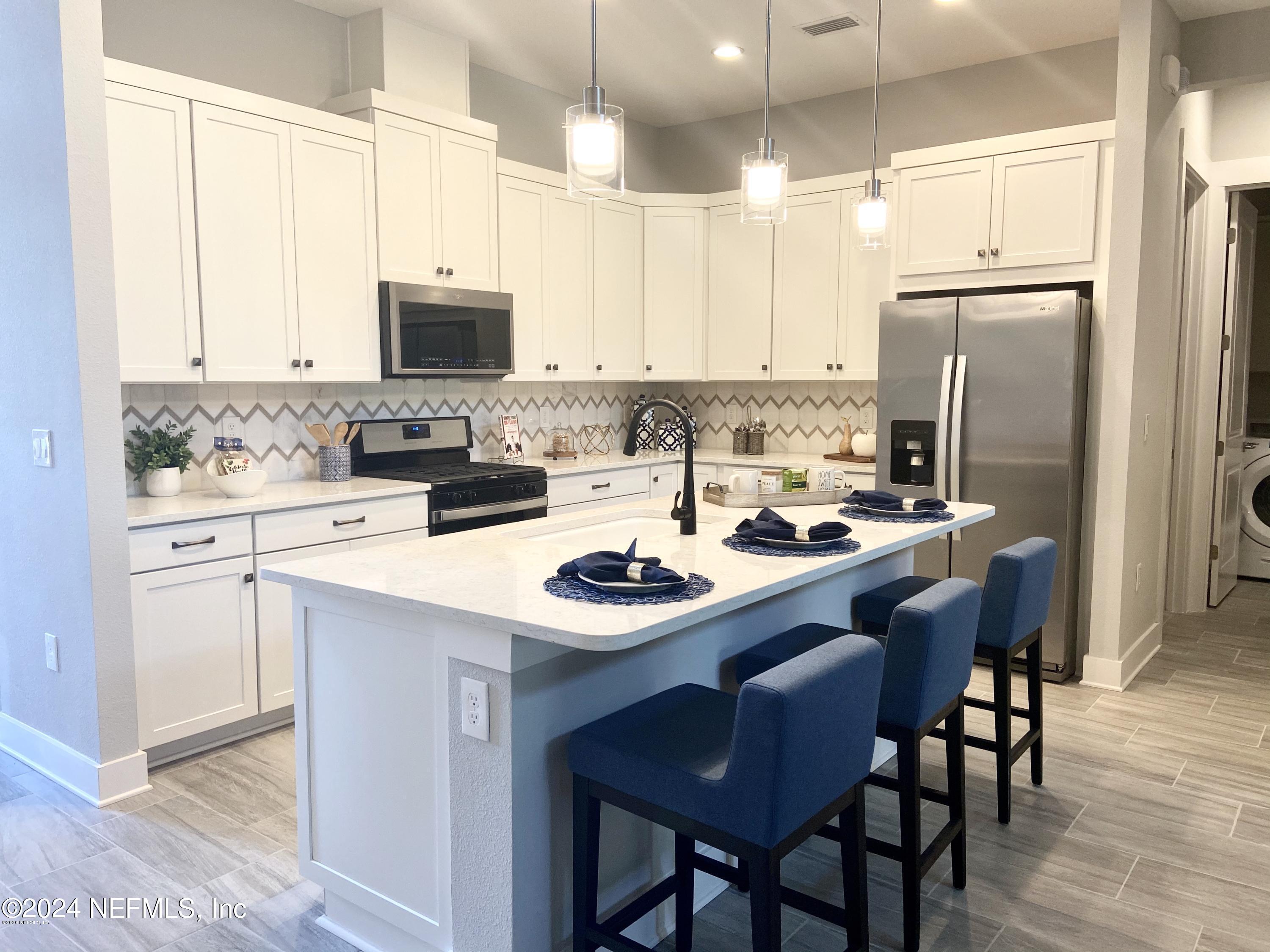 a kitchen with a sink and chairs