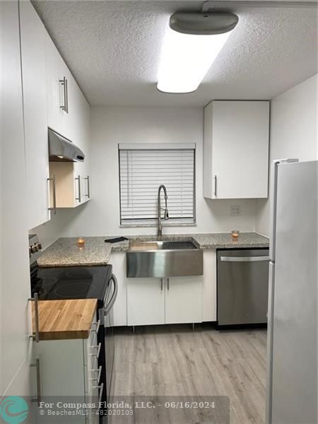 a kitchen with a sink and a stove top oven