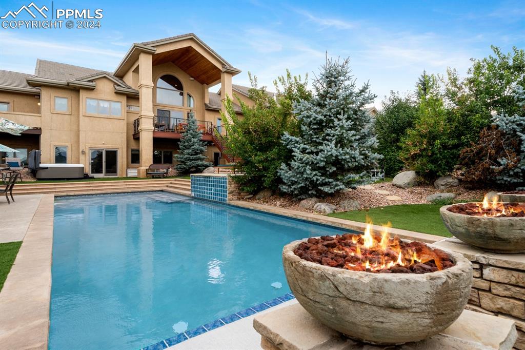 a front view of a house with a yard fountain and a fire pit