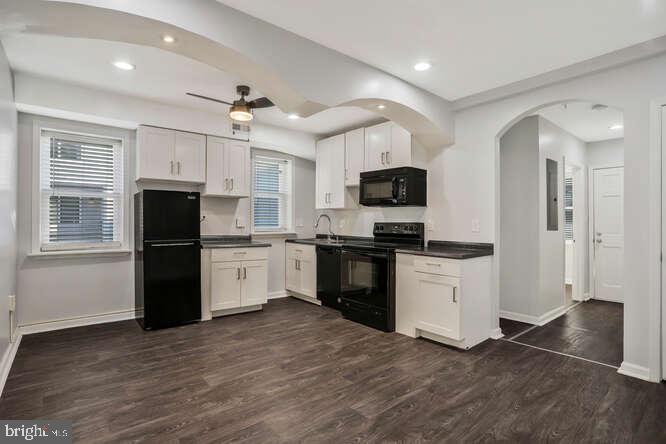 a kitchen with granite countertop a refrigerator stove top oven and sink