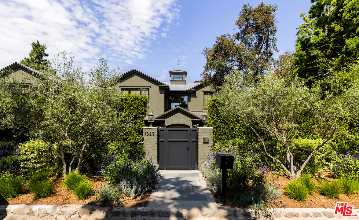 a front view of a house with a yard and tree s