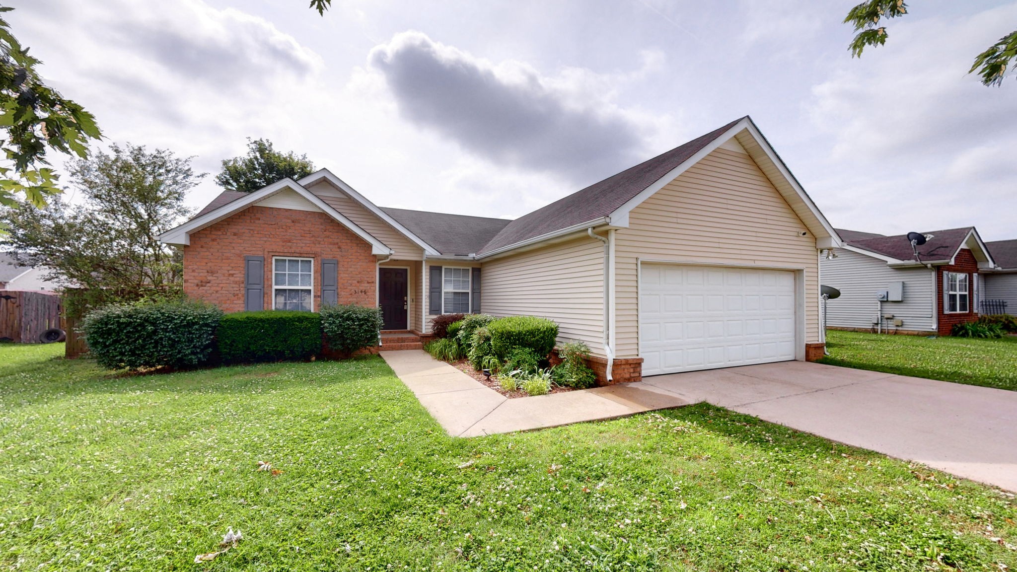 a front view of a house with yard and green space