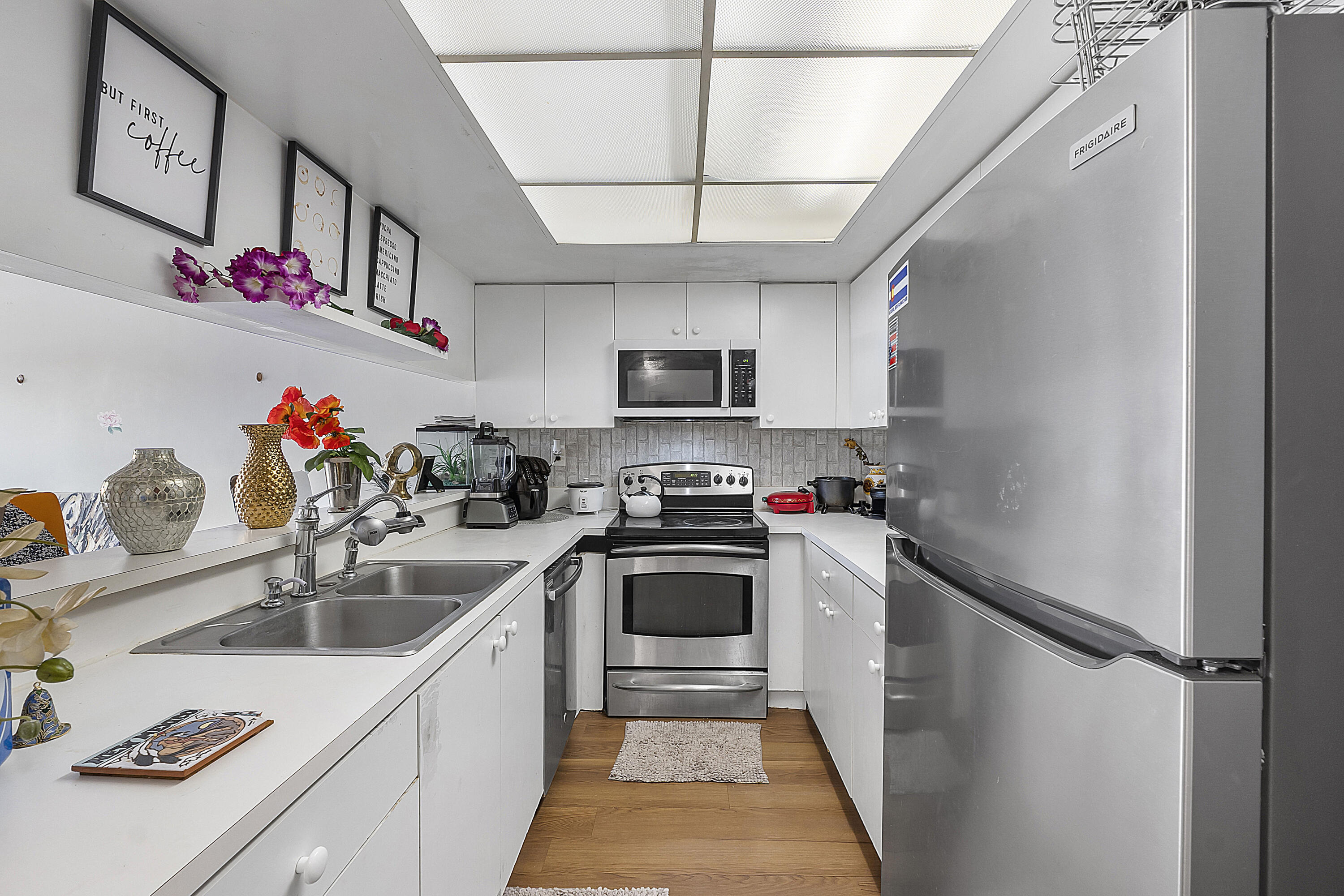 a kitchen that has a sink cabinets stainless steel appliances and a window