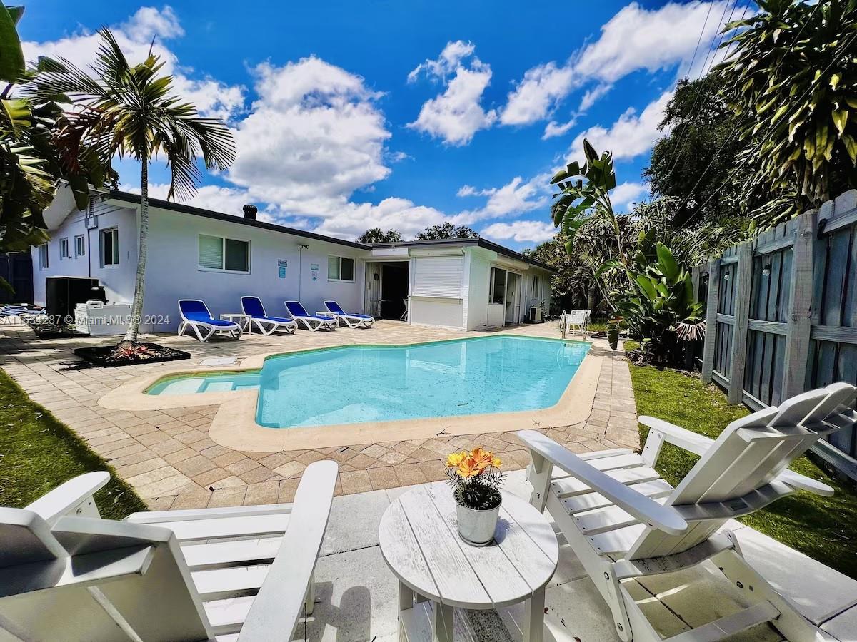 a view of a house with backyard and sitting area