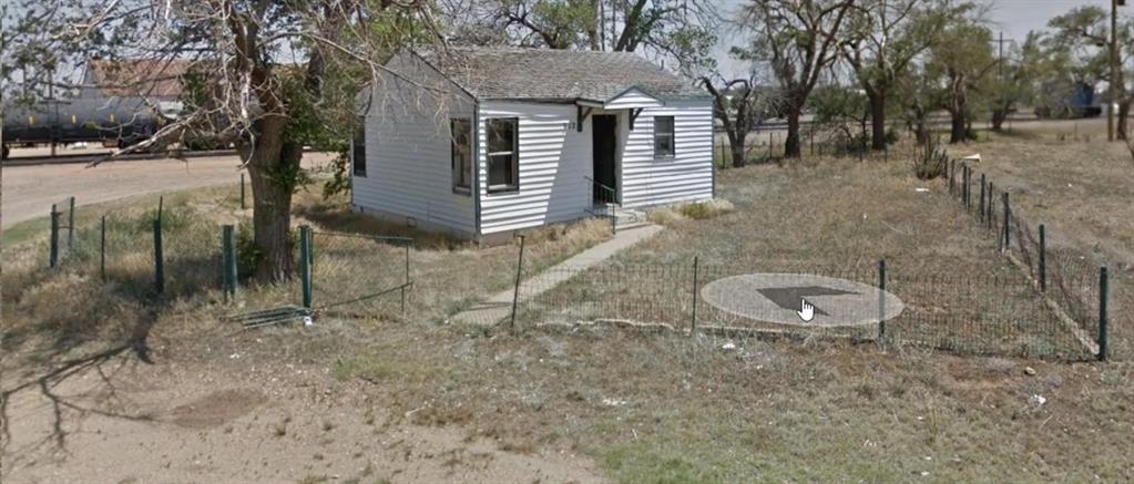 a view of a house with backyard and trees