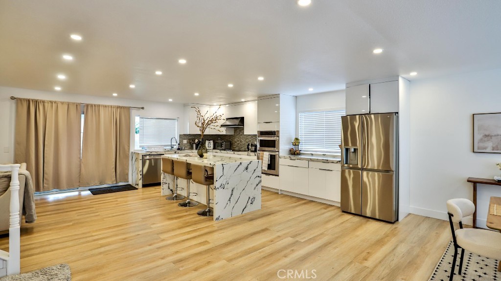 a kitchen with stainless steel appliances a refrigerator and a stove top oven