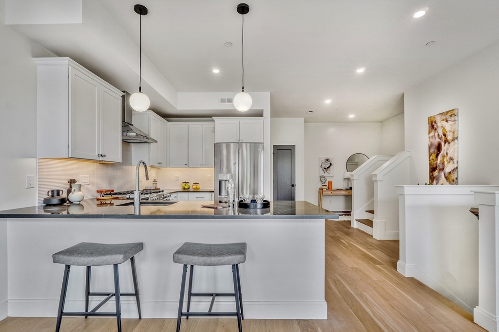 a kitchen with stainless steel appliances kitchen island a large island in the center and cabinets