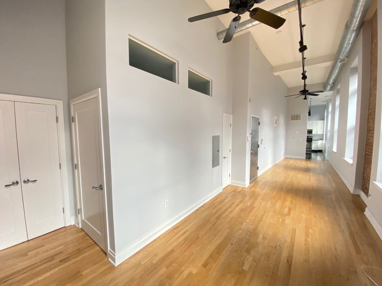 a view of a big room with wooden floor and a ceiling fan