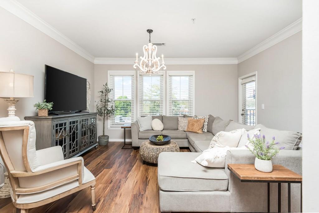 a living room with furniture a flat screen tv and a large window