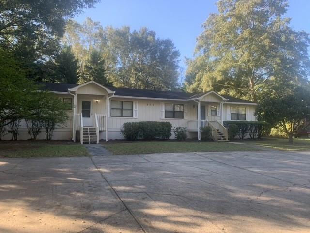 a front view of a house with a yard and trees