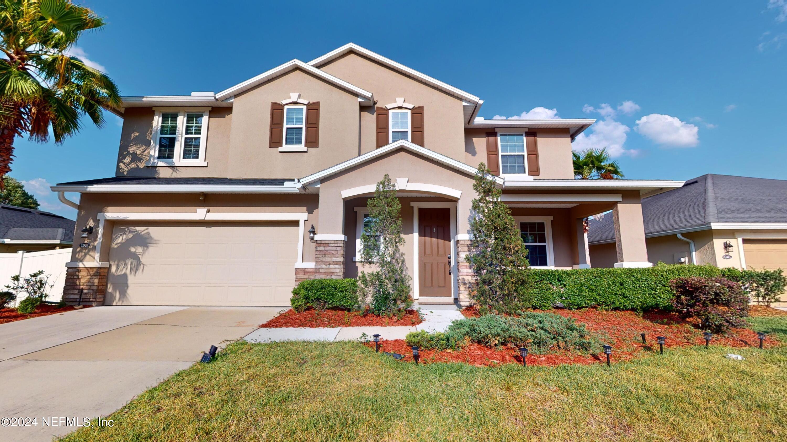 a front view of a house with a yard and garage