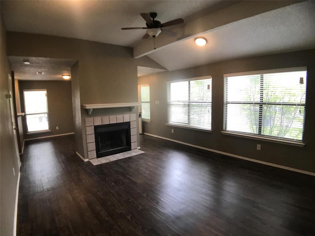 an empty room with floor to ceiling windows and fireplace