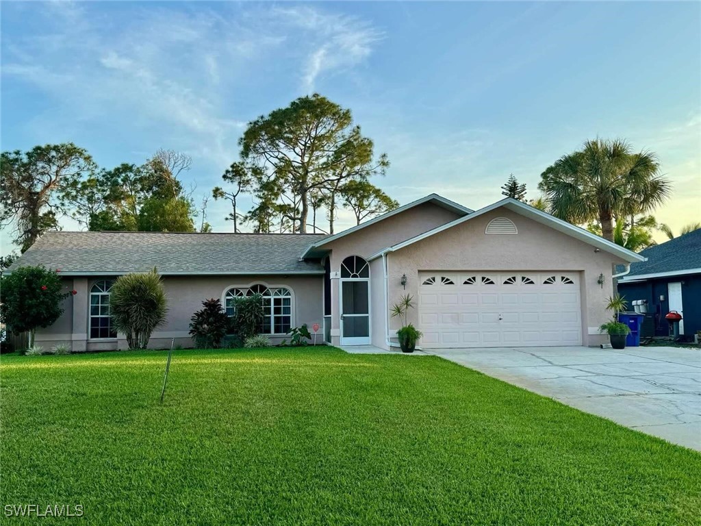 a view of a house with a yard and tree