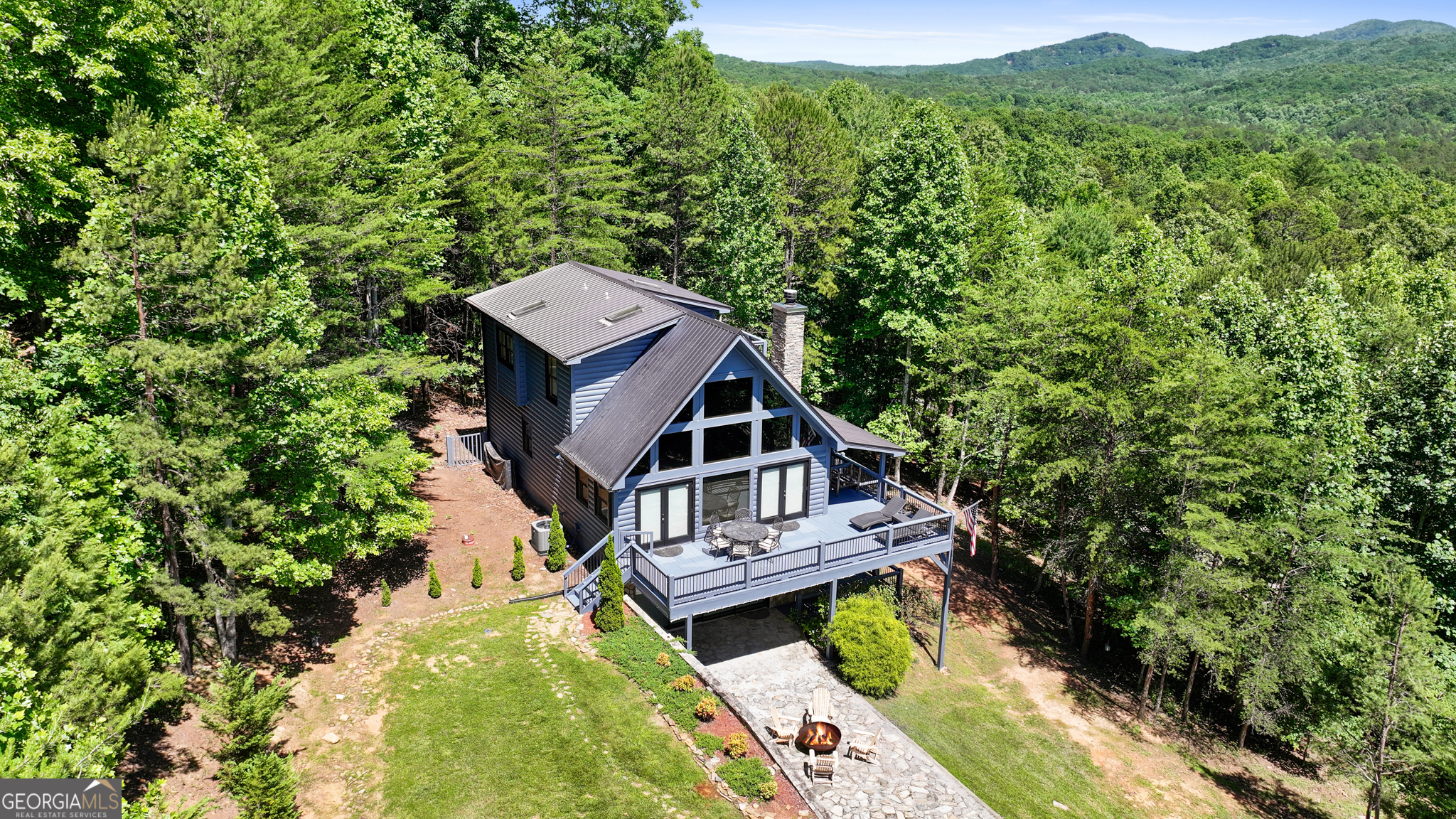 a view of a house with a big yard plants and large trees