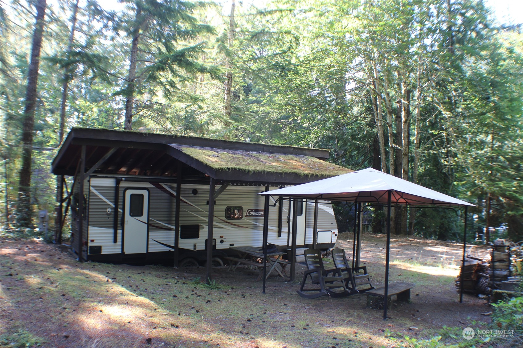 a backyard of a house with table and chairs under an umbrella