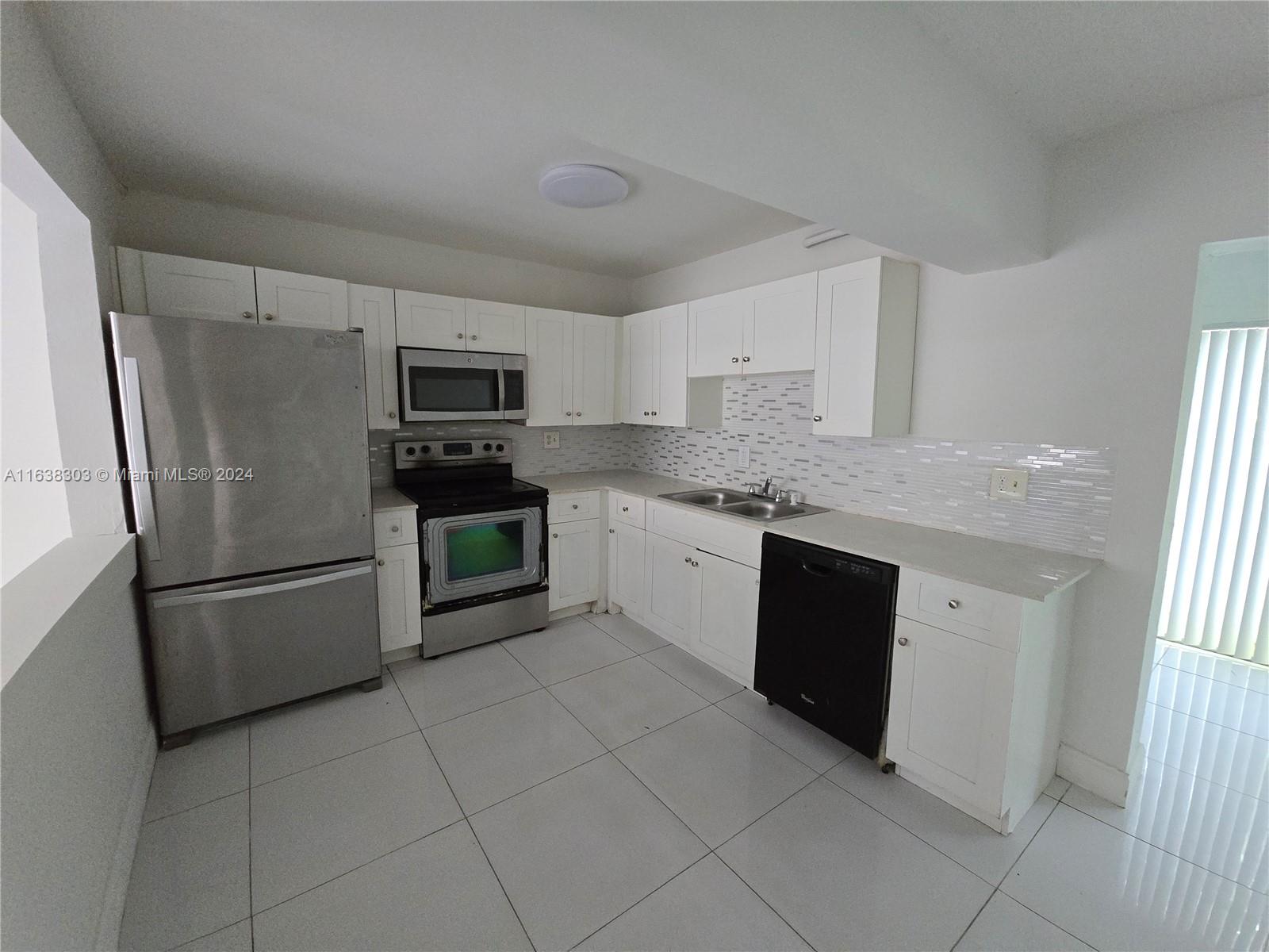 a kitchen with a refrigerator sink and microwave