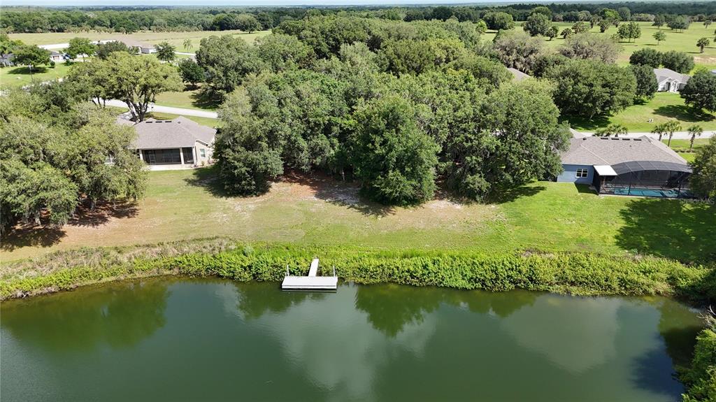 an aerial view of residential houses with outdoor space and lake view