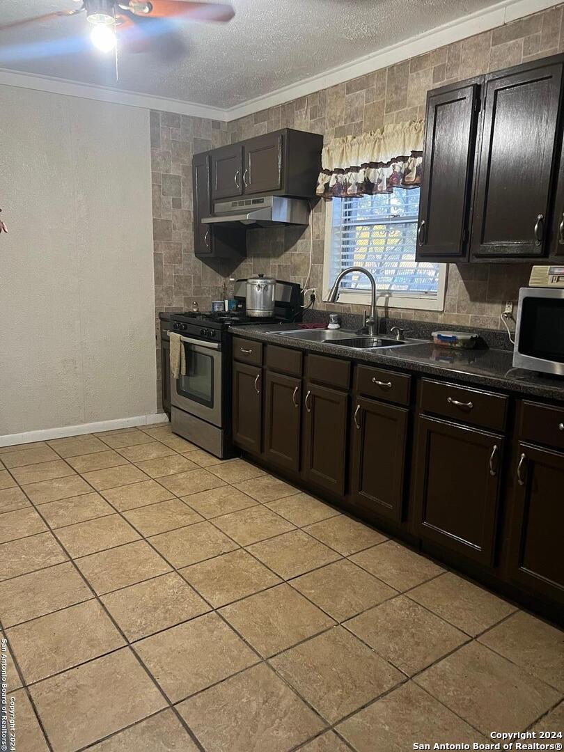 a kitchen with stainless steel appliances a sink stove and cabinets