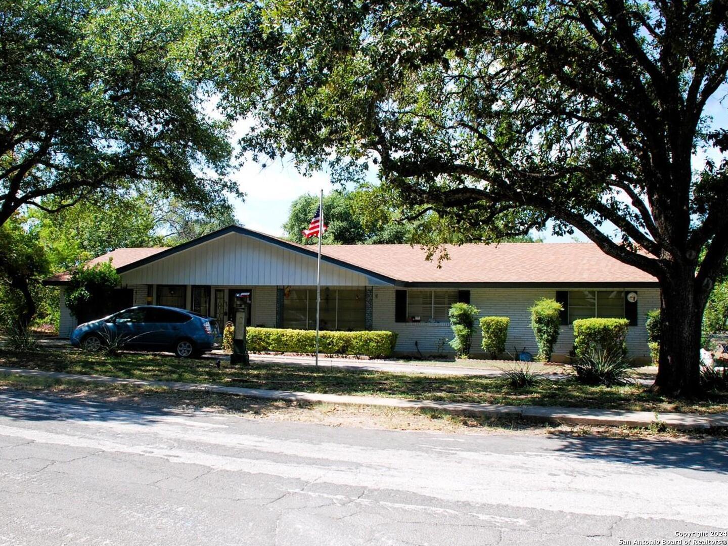 a front view of a house with a yard and an trees