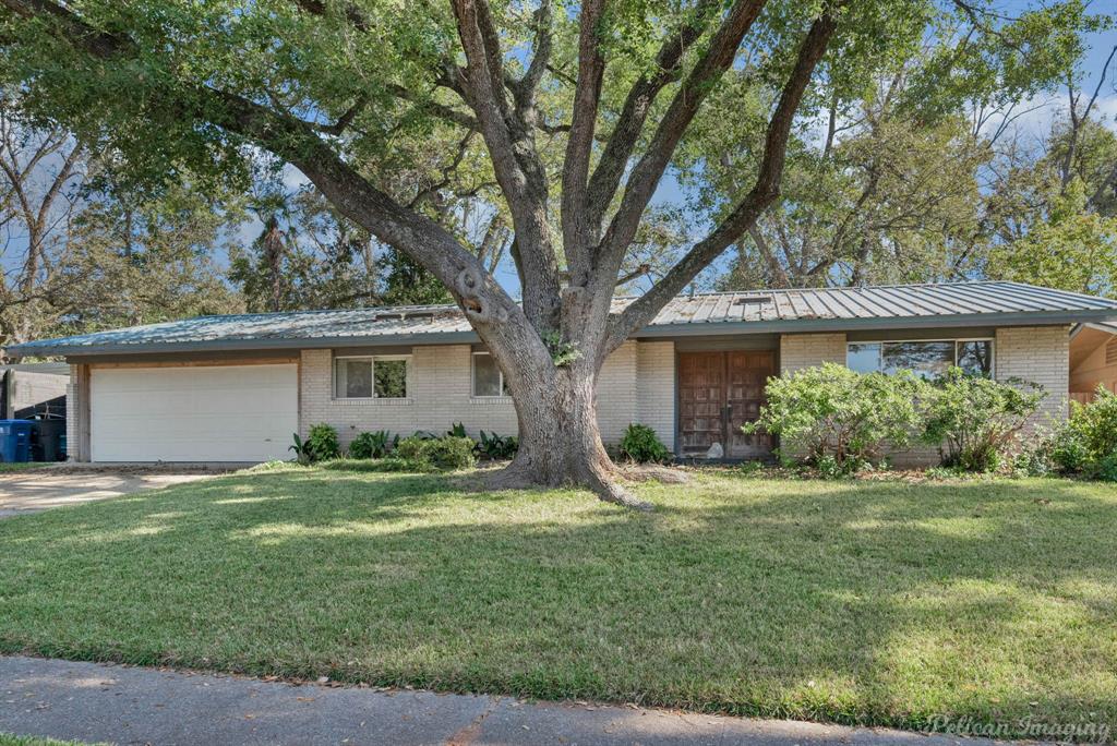 a view of a house with a yard and potted plants large tree