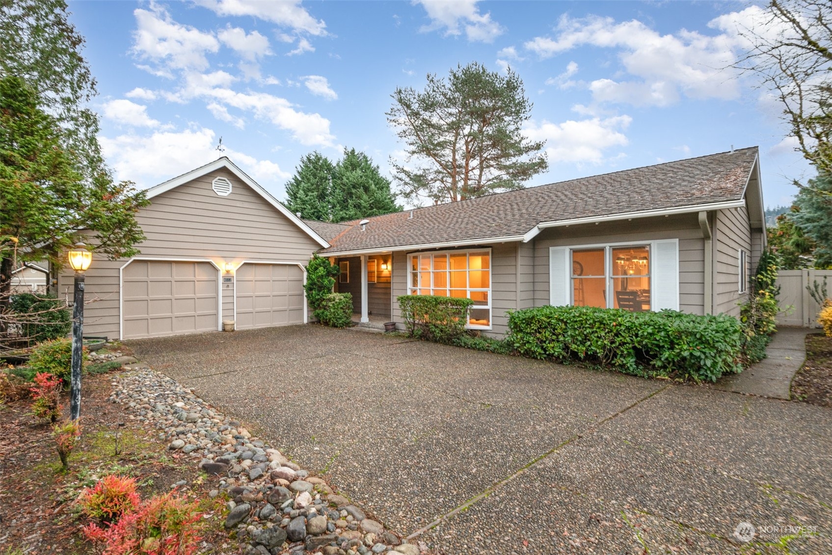 a view of a house with a small yard and large tree