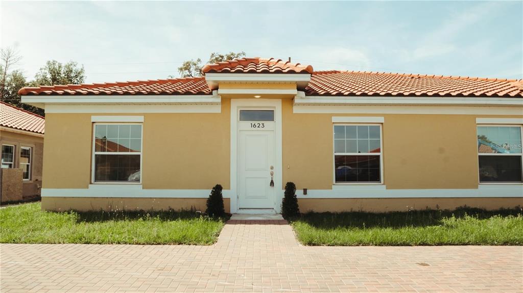 a front view of a house with a garden