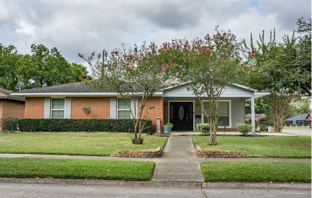 a front view of a house with a yard and trees