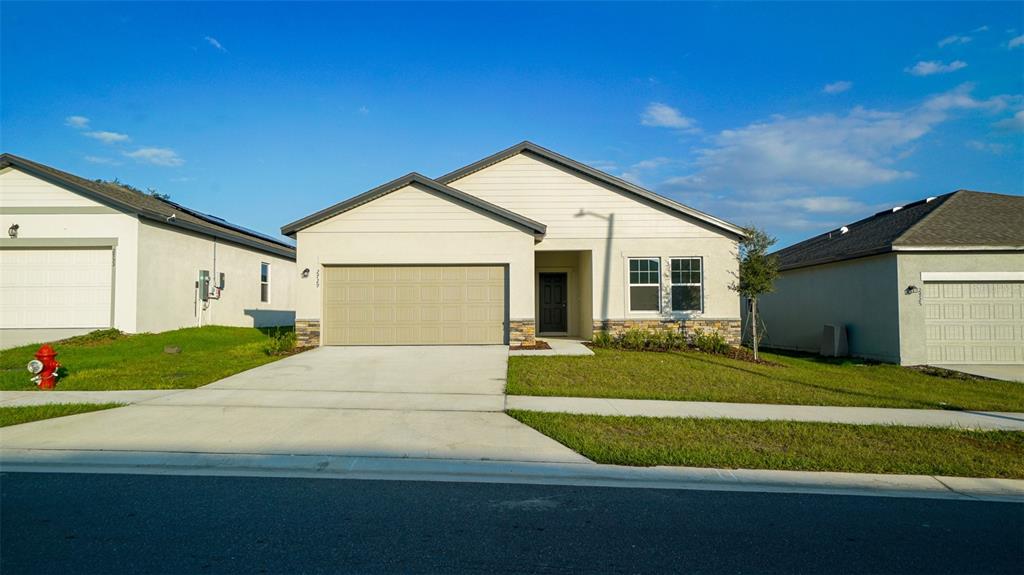 a front view of a house with a yard and garage