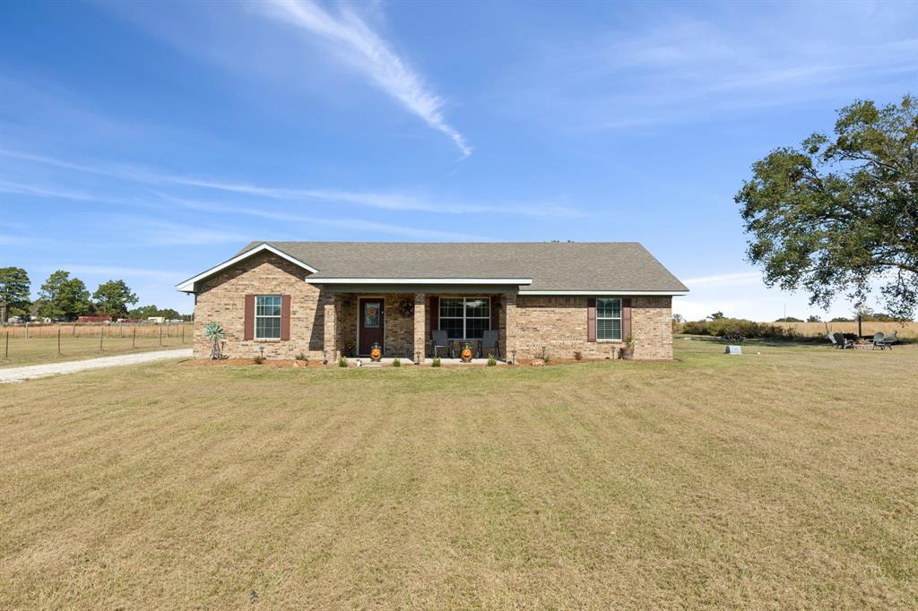 a front view of house with yard and lake view