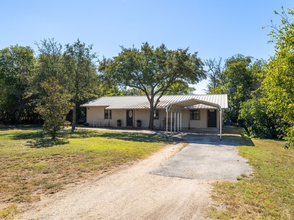 a front view of a house with a yard and trees