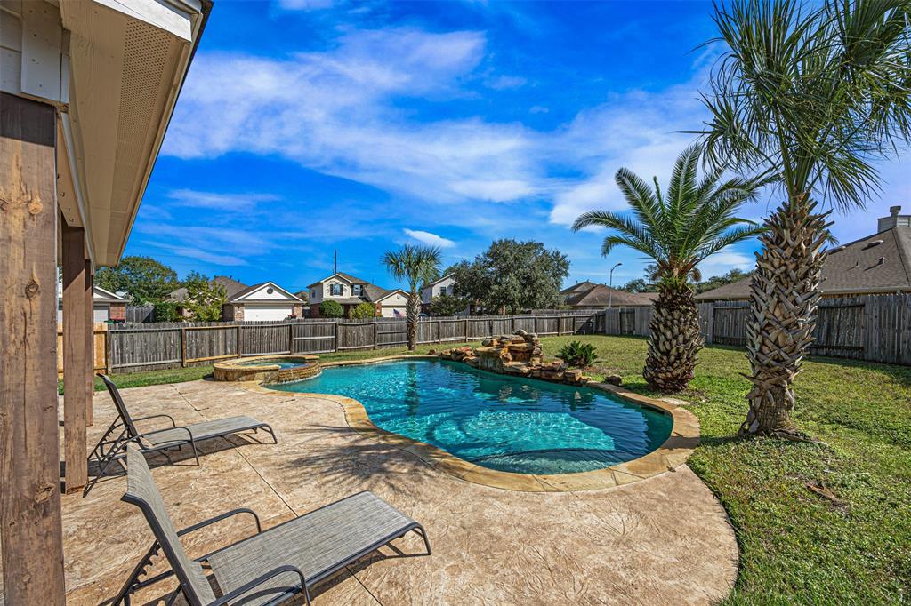 a view of a backyard with plants and swimming pool