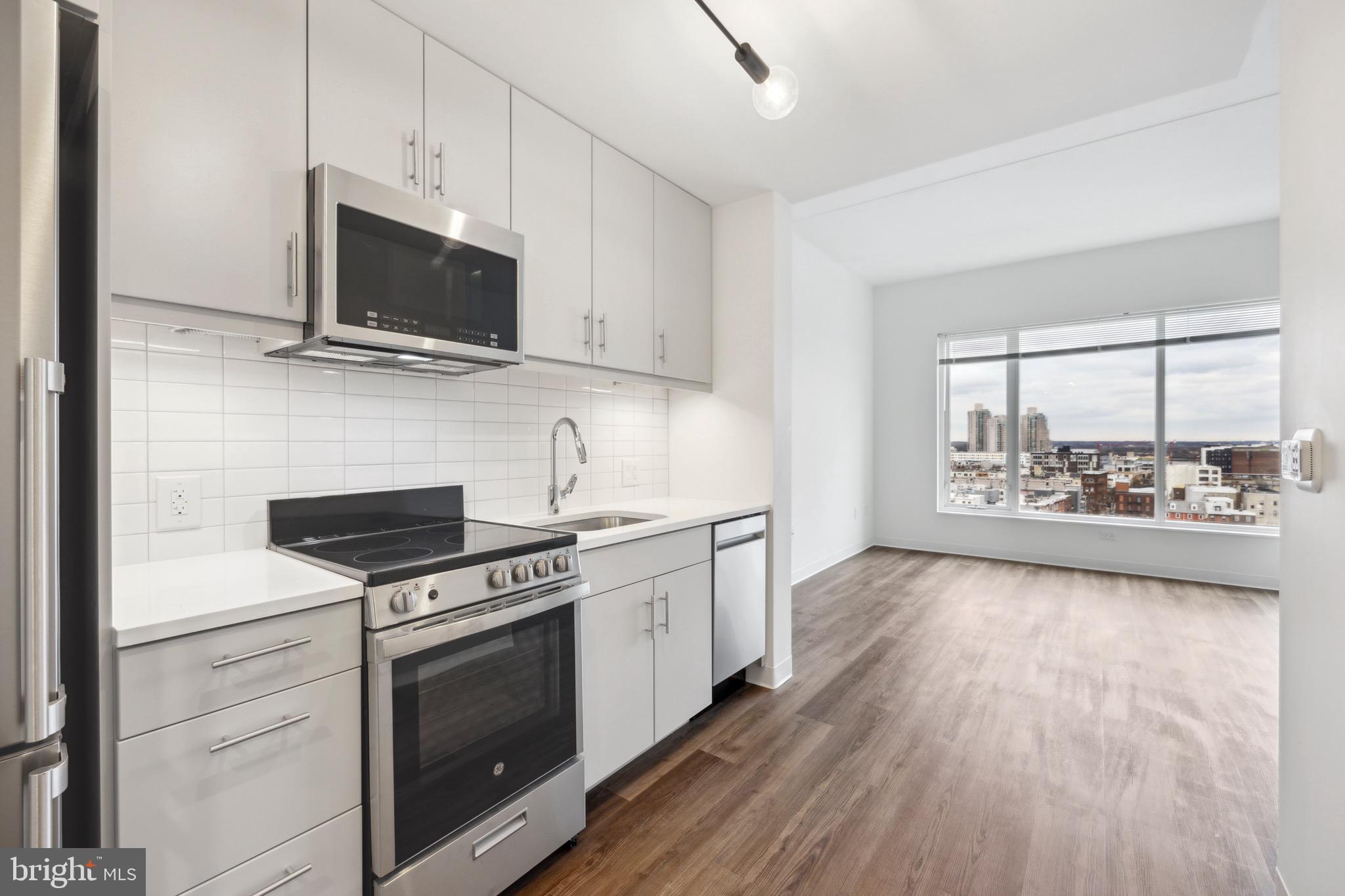 a kitchen with stainless steel appliances a stove microwave and sink