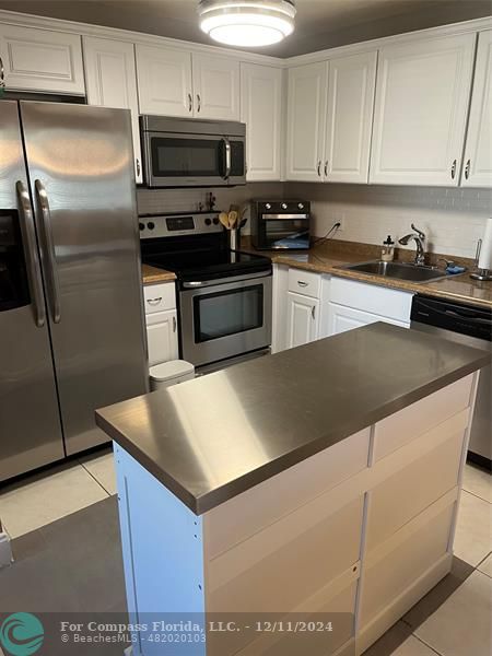 a kitchen with cabinets and stainless steel appliances