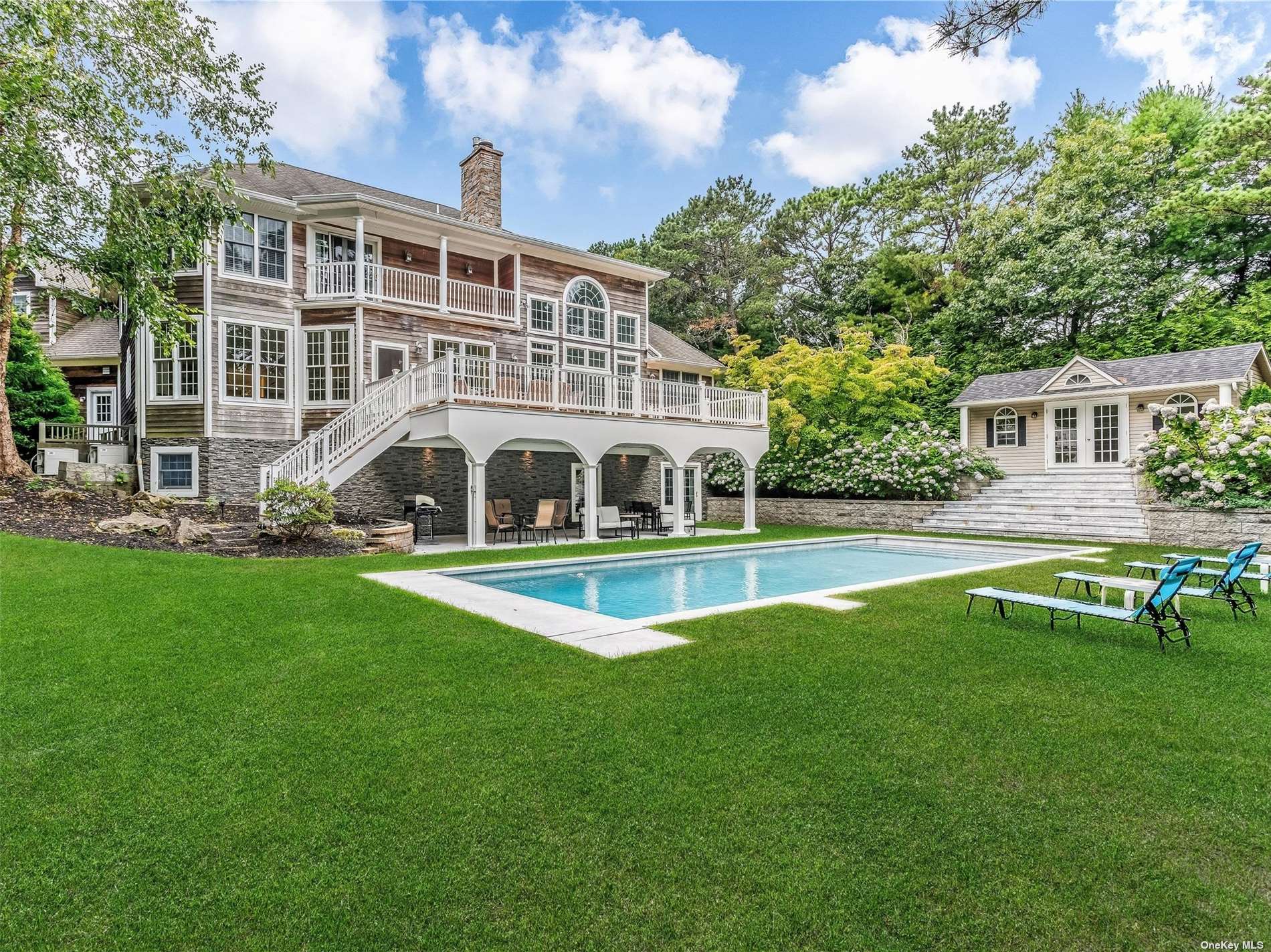 a view of a house with a swimming pool and sitting area