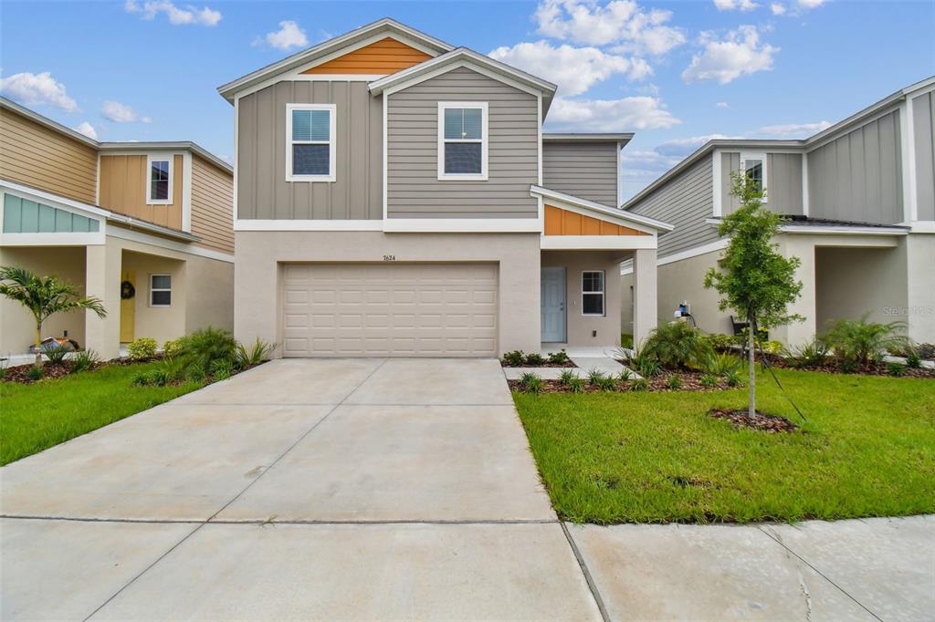 a front view of a house with a yard and garage