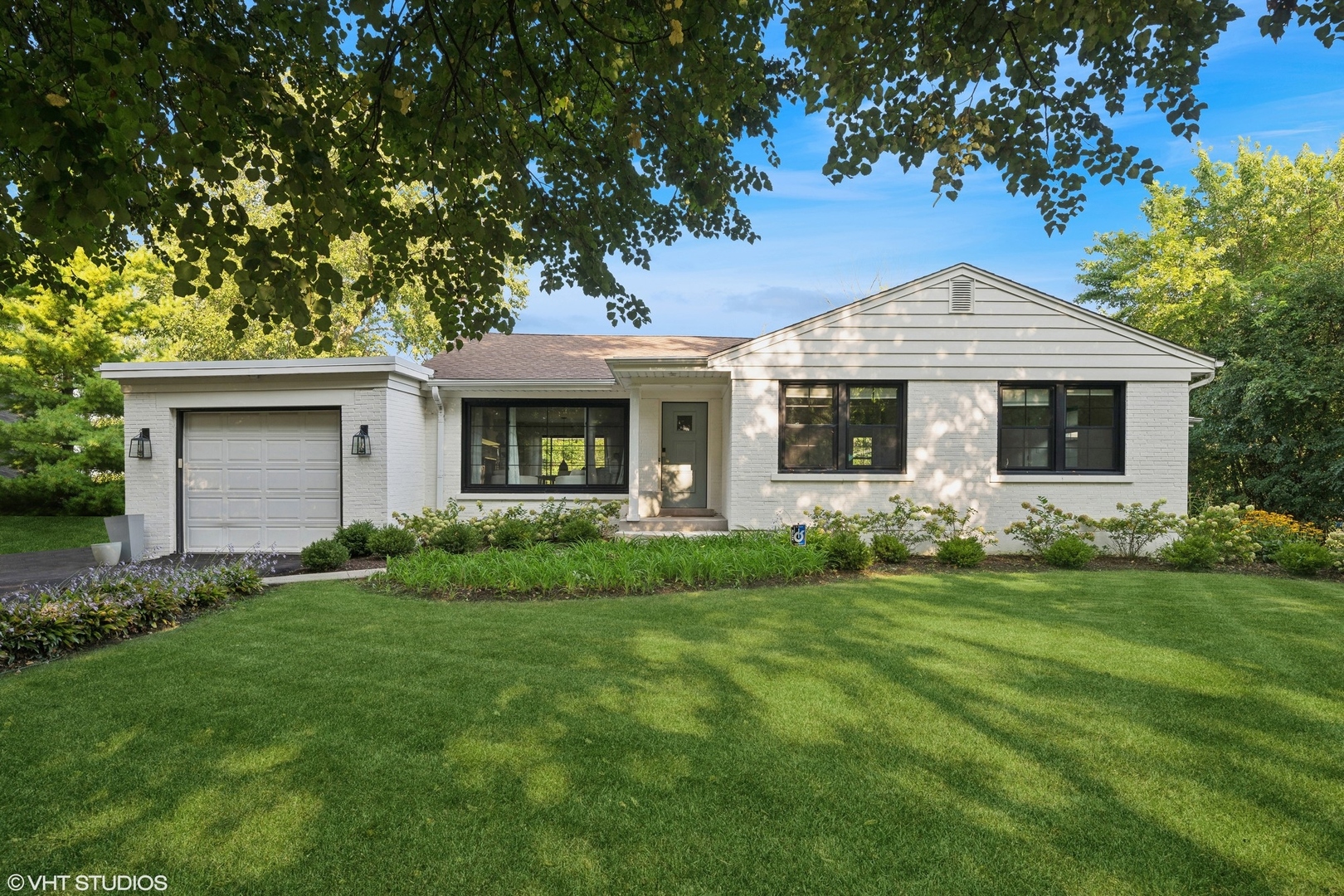 a front view of a house with a garden